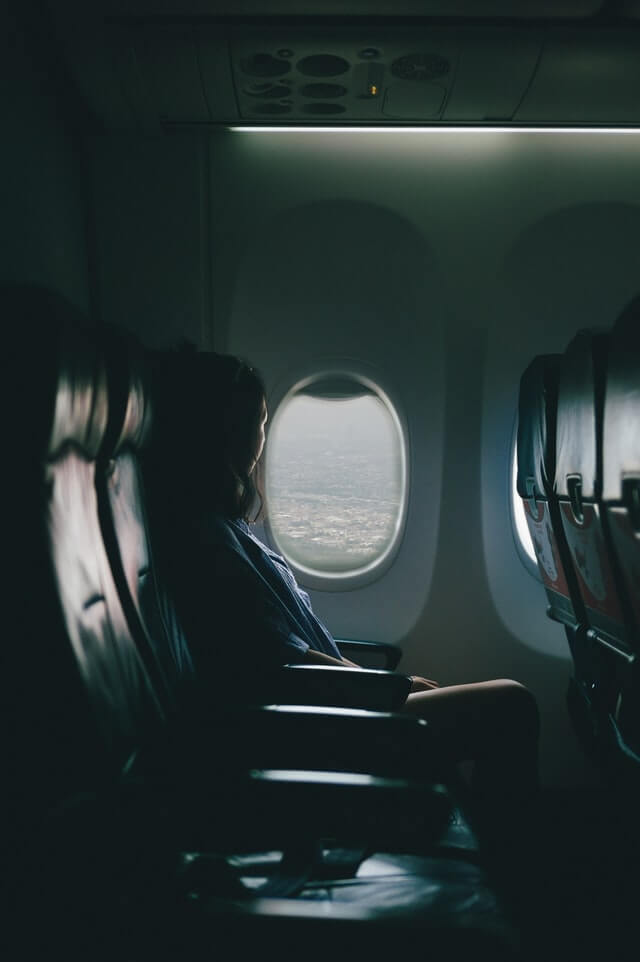 Chica viendo desde la ventana del avión